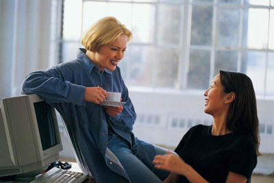 2 Women friends chatting in office - funny story